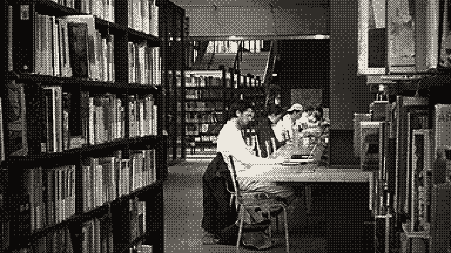 A student at a desk between library shelves