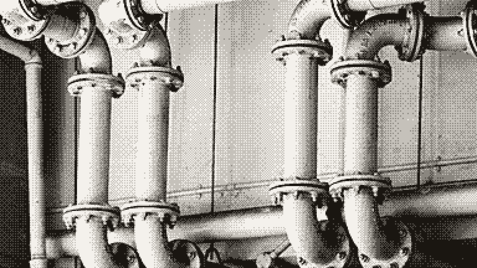 Metal pipes with flanged joints running along a wall